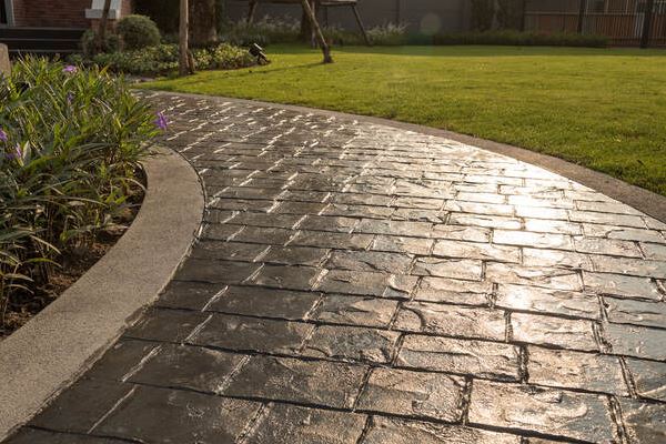 Dark Grey Stamped Concrete Walkway with Light Grey Accents in Backyard
